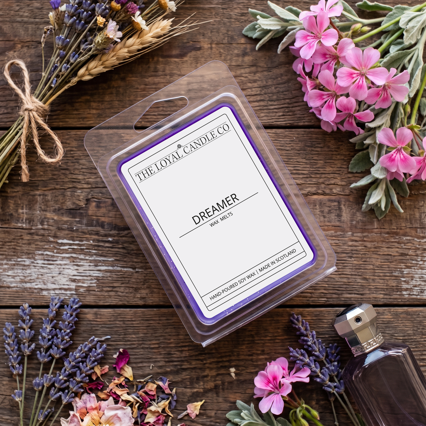Dreamer wax melt clamshell with dried lavender on a dark wood background