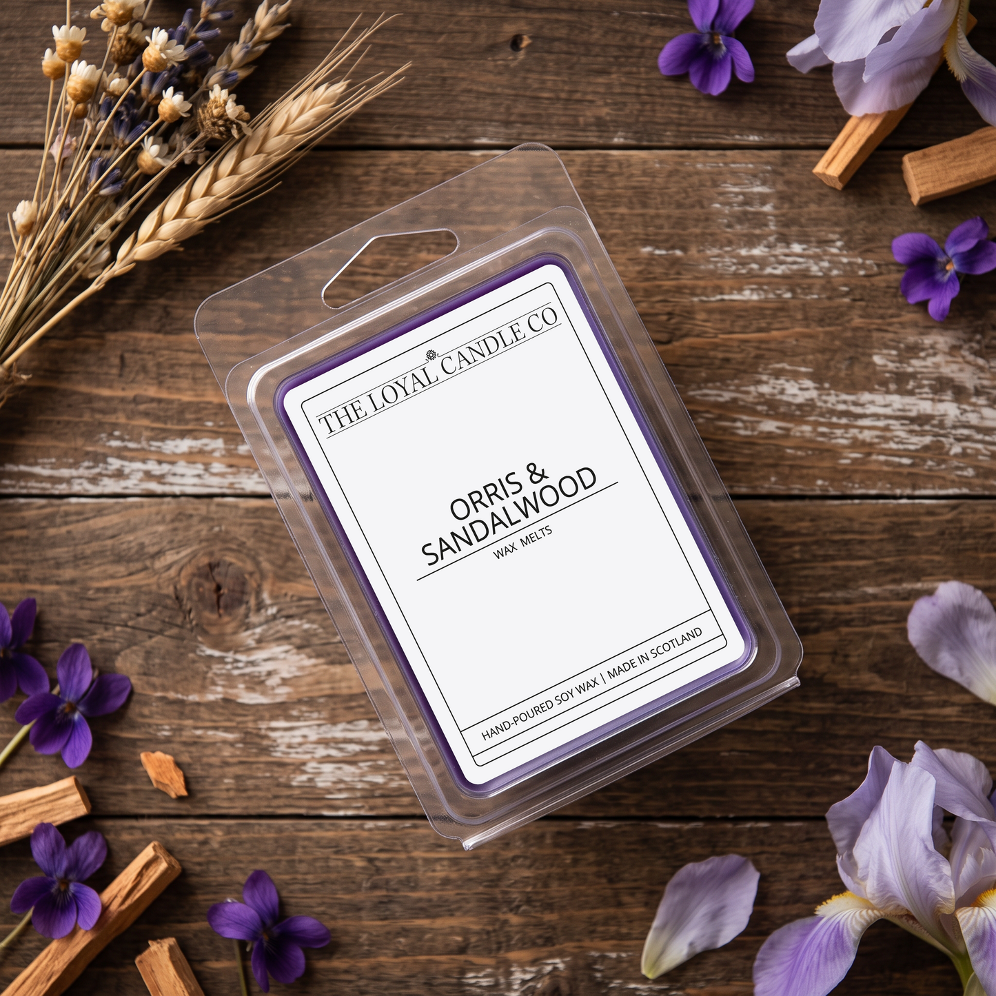 Orris & Sandalwood wax melt clamshell on a dark wood background.