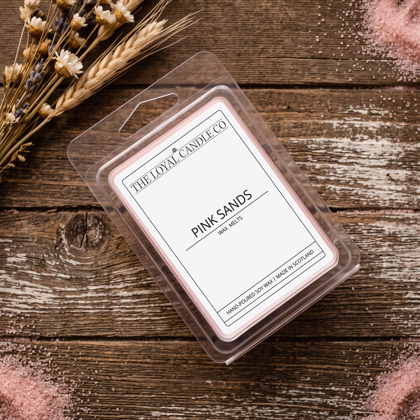 Pink Sands wax melt clamshell on a dark wood background.
