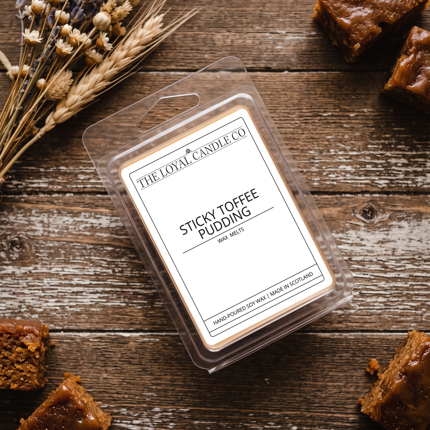 Sticky Toffee Pudding wax melt clamshell on a dark wood background.