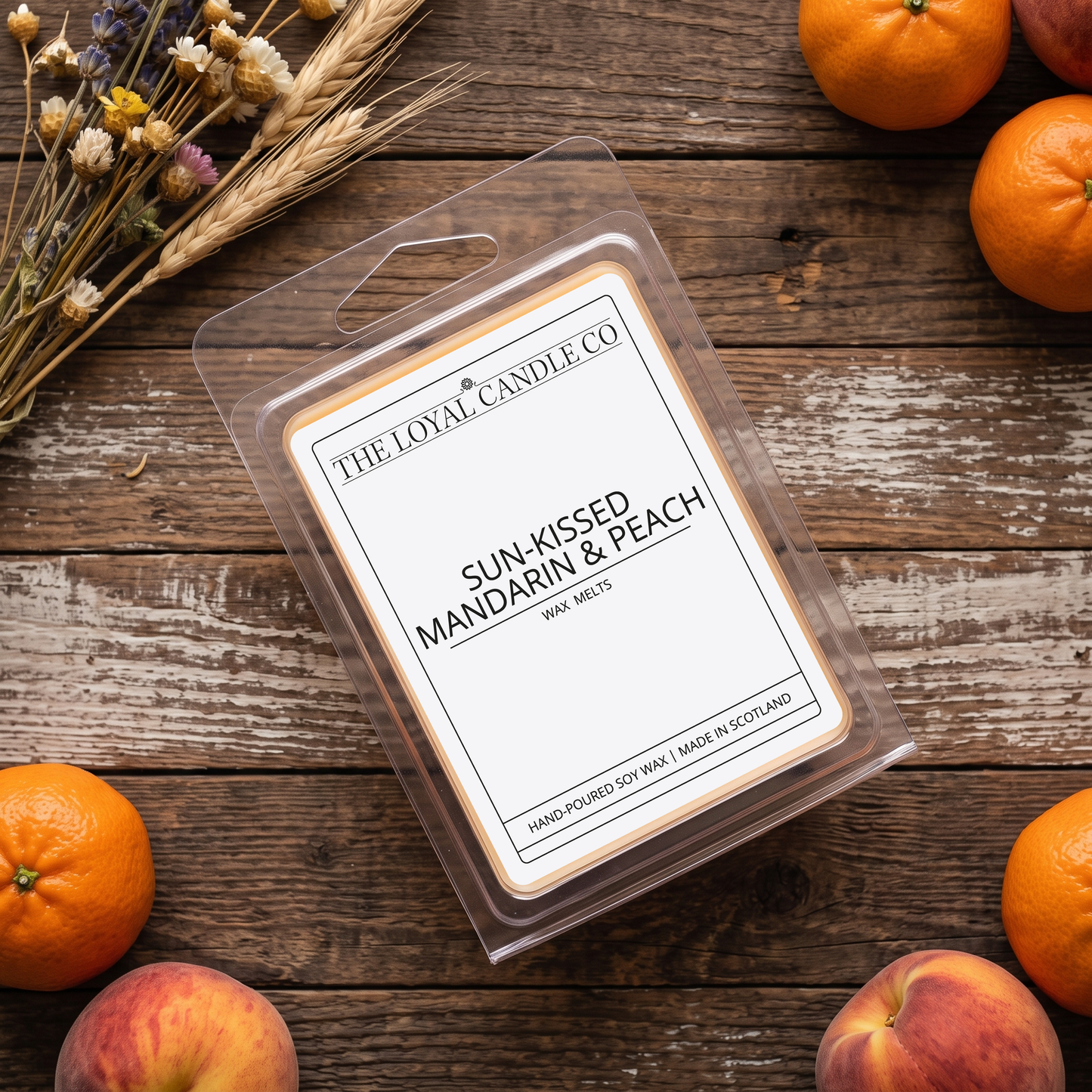 Sun-Kissed Mandarin & Peach wax melt clamshell on a dark wood background.
